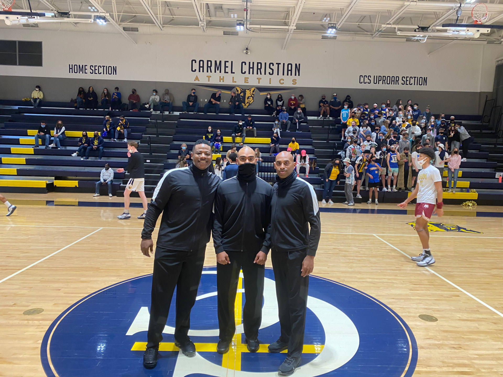 Let'em Play officials in warm-up jackets on a Charlotte-area gym court